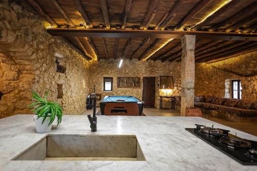 a large stone room with a pool table in it at Beit el loz in Ghazīr