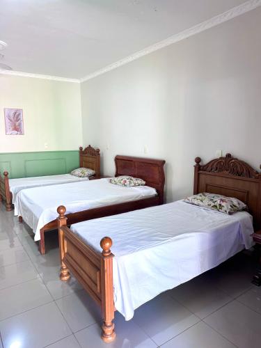 two beds in a room with white walls at quarto suíte privativo em campinas para até 4 pessoas in Campinas