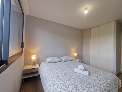 a bedroom with a bed with two towels on it at Le Savannah #Parking#Terrasse in Clermont-Ferrand