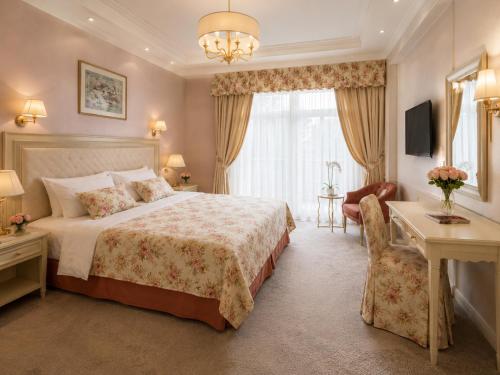 a bedroom with a bed and a desk and a chair at Zlatý Sloup in Karlovy Vary