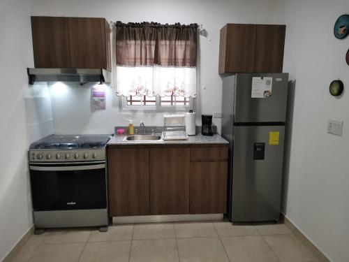 a kitchen with a stove and a sink and a refrigerator at Casita del Valle in San Cristóbal