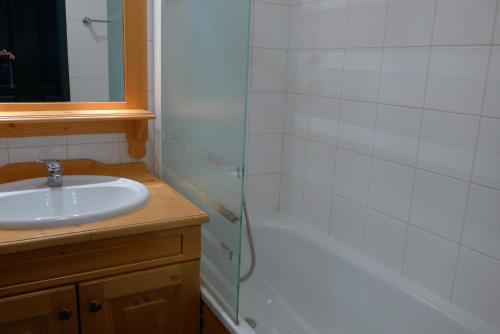 a bathroom with a sink and a shower and a tub at A27 Chalet du Galibier in Valloire