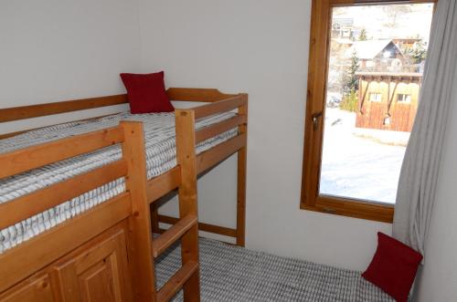 a room with two bunk beds and a window at A27 Chalet du Galibier in Valloire