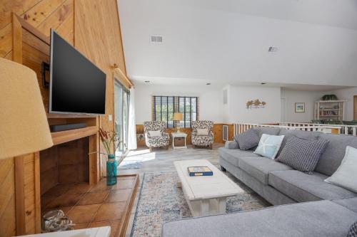 a living room with a couch and a flat screen tv at 2507 - Salty Sandpiper in Duck