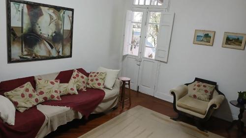 a living room with a couch and a chair at Muito espaço e natureza no meio da cidade in Santos