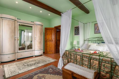 a bedroom with green walls and a bed with a canopy at Villa Sabrina by PosarelliVillas in San Gimignano
