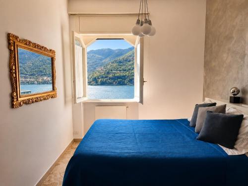 a bedroom with a blue bed and a window at Botanic Garden Lake Como in Blevio