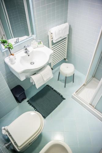 a blue bathroom with a sink and a toilet at Hotel La Fonte in Osimo