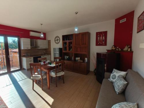 a living room with a couch and a table and a kitchen at Monolocale moderno in centro storico in Scano Montiferro