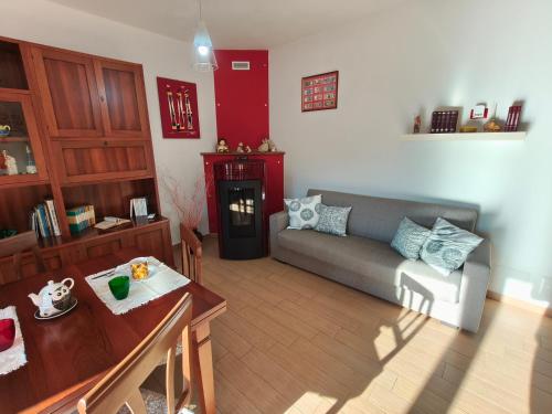 a living room with a couch and a table at Monolocale moderno in centro storico in Scano Montiferro
