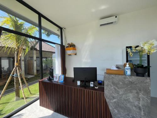an office with a desk with a computer and a palm tree at Ulu Apsura Villas in Uluwatu