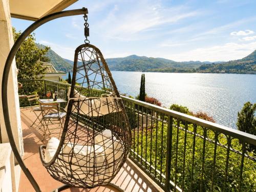 a swing on a balcony overlooking a lake at Botanic Garden Lake Como in Blevio