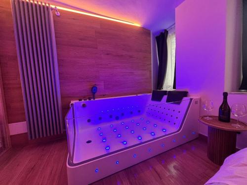 a purple room with a bed and a table with wine glasses at Romantic Spa del Lago in Viverone