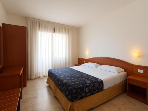 a bedroom with a large bed in a room at Smart Rooms Miramare in Sottomarina