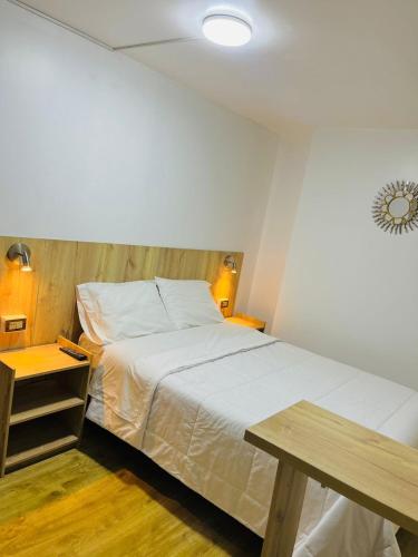 a bedroom with a large bed and a table at Alpacasa Arequipa in Arequipa