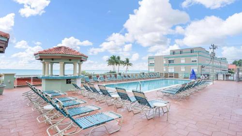 a pool with chairs and a gazebo next to a building at Hollywood Beach Tower - Hotel Room in Hollywood