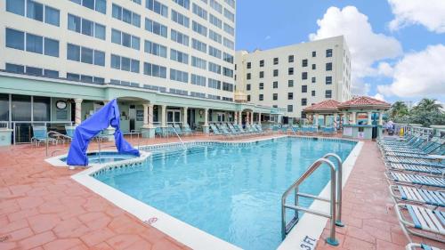 a pool at a hotel with chairs and a building at Hollywood Beach Tower - Hotel Room in Hollywood
