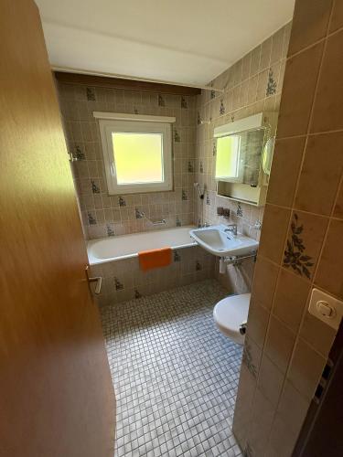 a bathroom with a tub and a sink and a toilet at Gonenstein 11 in Leukerbad