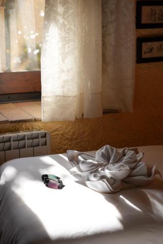 a white bed in a room with a window at Mas Joanmiquel - Masía histórica exclusiva in Les Olives