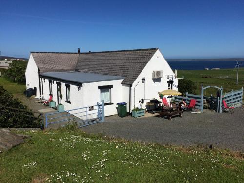 a white house with a table and a picnic table at Aviedale Suite in Gorseness