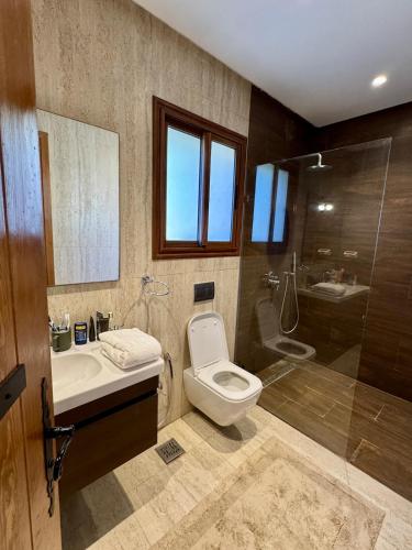 a bathroom with a toilet and a sink and a shower at Le Forestier in Dar el Hajri