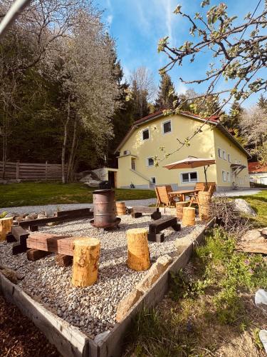 a garden with logs and a house in the background at Ferienwohnung Huskyhausen - Schlittenhunde Erlebnisse & Urlaub mitten in der Natur! in Klaffer am Hochficht