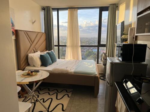 a bedroom with a bed with a large window at Victor Airport suites in Nairobi