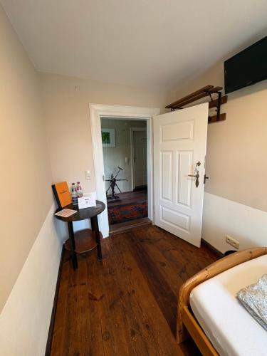 a bedroom with a bed and a table and a door at Alandblick in Wanzer