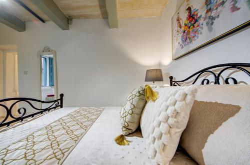 a white bedroom with a bed and a lamp at Valletta Boutique Residence in Valletta