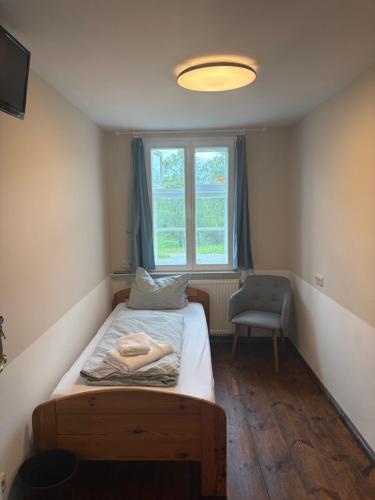 a bedroom with a bed and a window and a chair at Alandblick in Wanzer