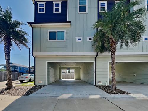 a building with a garage with palm trees in front at Port As Flip Flops & Pop Tops in Port Aransas