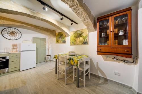 a kitchen with a table and chairs in a room at Valletta Boutique Residence in Valletta