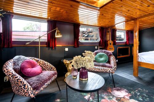 a room with two chairs and a table and a bed at Asile Flottant in Amsterdam