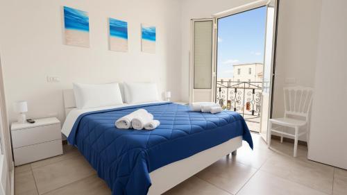 a bedroom with a blue bed and a balcony at Il Marchesino B&B in Pizzo