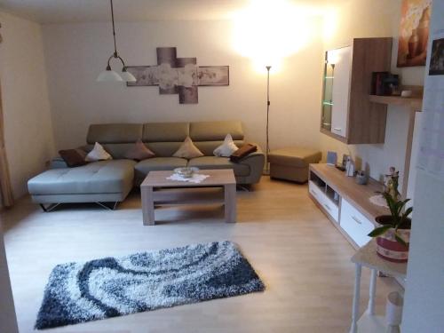 uma sala de estar com um sofá e uma mesa em Ferienwohnung Diester Riegelsberg em Walpershofen