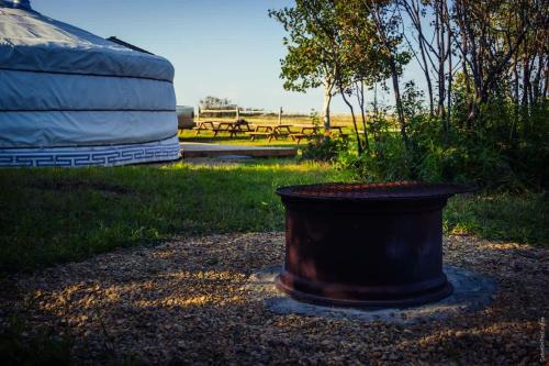 a black bucket sitting in the middle of a yard at COTC - The Coulee Yurt - Suite in Castor