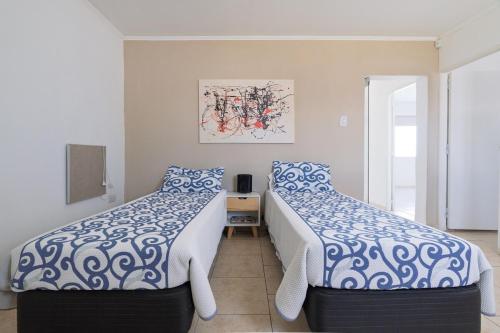 a bedroom with two beds with blue and white sheets at Casa en San Rafael - 6 personas con parrilla y cochera in San Rafael