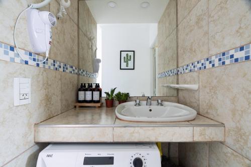 a bathroom with a sink and a washing machine at Casa en San Rafael - 6 personas con parrilla y cochera in San Rafael