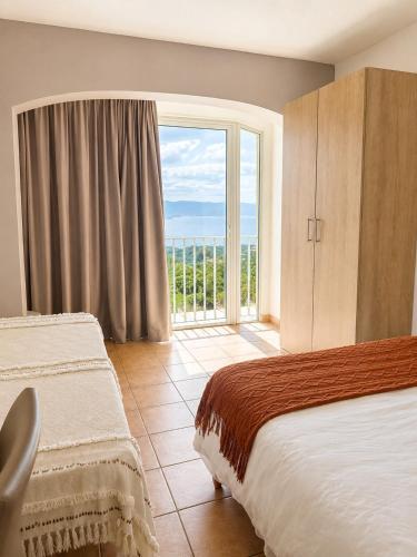 a hotel room with a bed and a large window at Hotel Alata in Alata