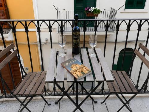 a table with a book and two glasses of wine at Appartamento in Centro casa vacanza in Scicli