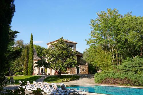 a villa with a swimming pool in front of a house at Mas Joanmiquel - Masía histórica exclusiva in Les Olives