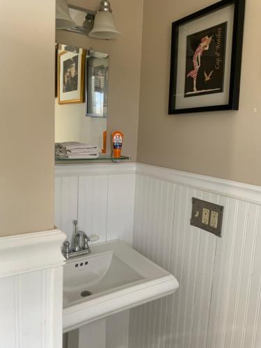 a bathroom with a white sink and a mirror at Half a Mansion in Pomfret