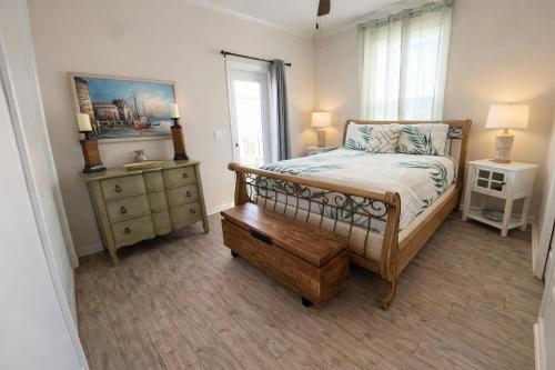 a bedroom with a bed and a dresser and a window at Beautiful Pensacola beach house in Pensacola Beach