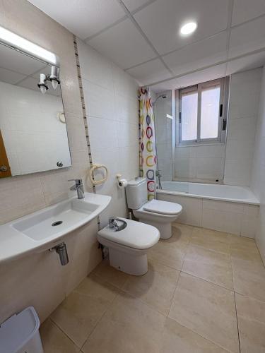 a bathroom with a toilet and a sink and a tub at Alpen1 Pompeya in Peniscola