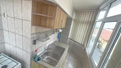 a small bathroom with a sink and a window at Apartament Ultra-Central Rm Valcea in Râmnicu Vâlcea