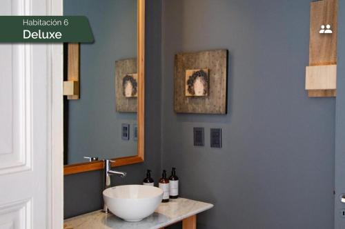 a bathroom with a bowl sink and a mirror at Casa Lahusen in Colonia del Sacramento