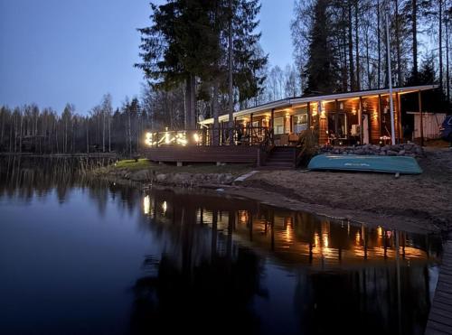 a house on the shore of a lake at night at Tilhi 1 Cottage in Piojärvi