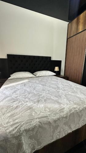 a bedroom with a bed with a white comforter at Beach Apartment Chakvi in Chakvi