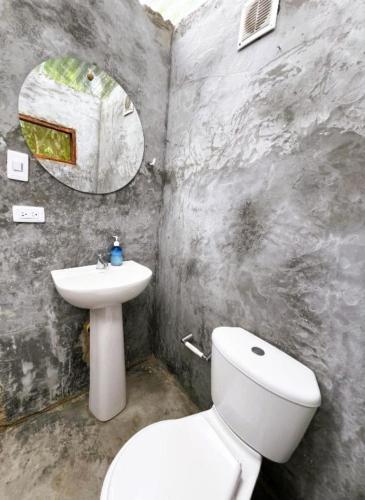 a bathroom with a white toilet and a sink at Glamping Kunna Tayrona in El Zaino