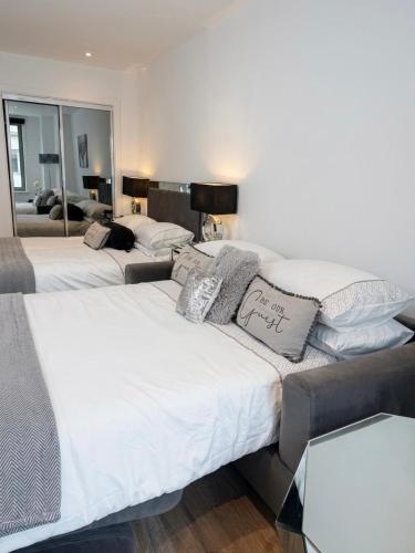 two beds in a room with a mirror at Blanco Brillo in Colchester